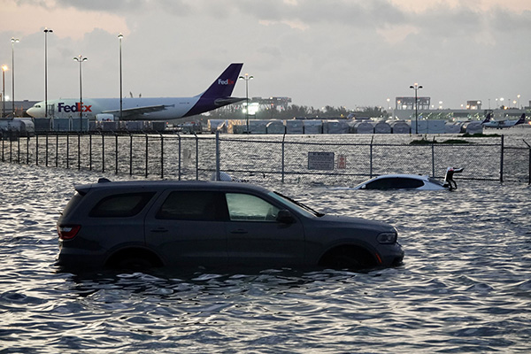 small photo showing a car being flooded with an airport in the background