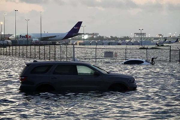 small photo showing a car being flooded with an airport in the background