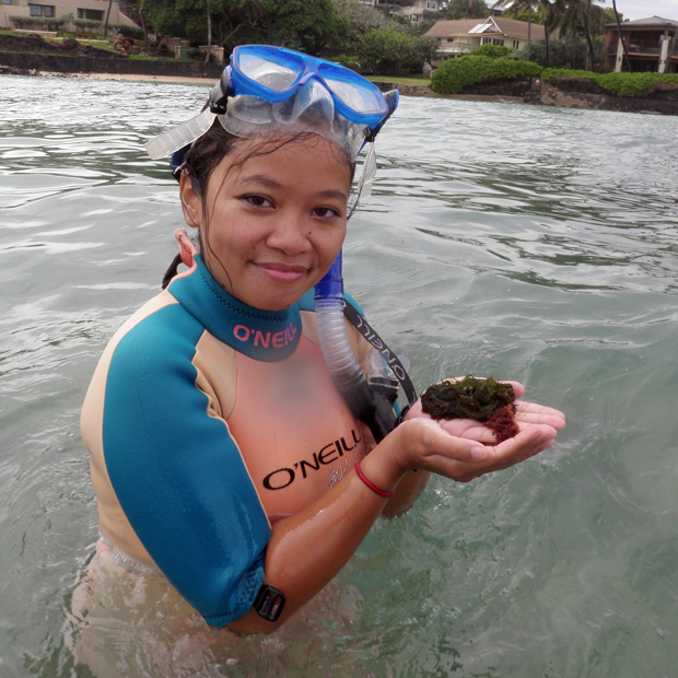 Photo of Flo La Valley in the water wearing snorkeling mask, holding ocean plants