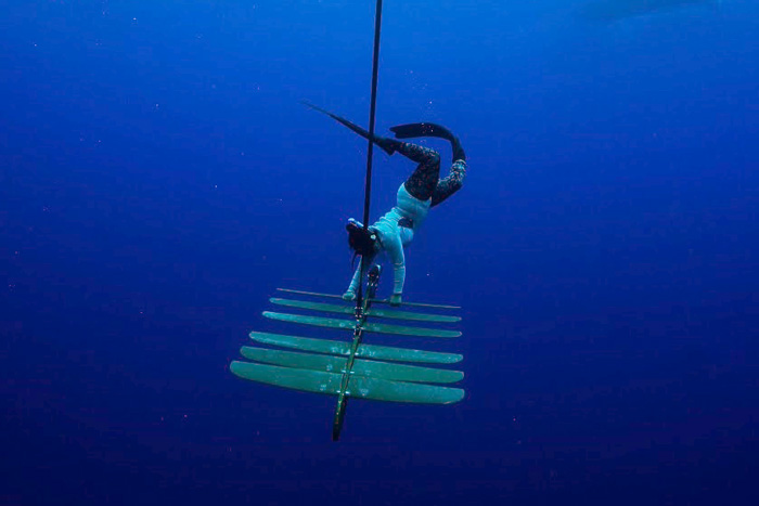 Underwater photo of Flo La Valley freediving in Hawaii while working on a wave glider