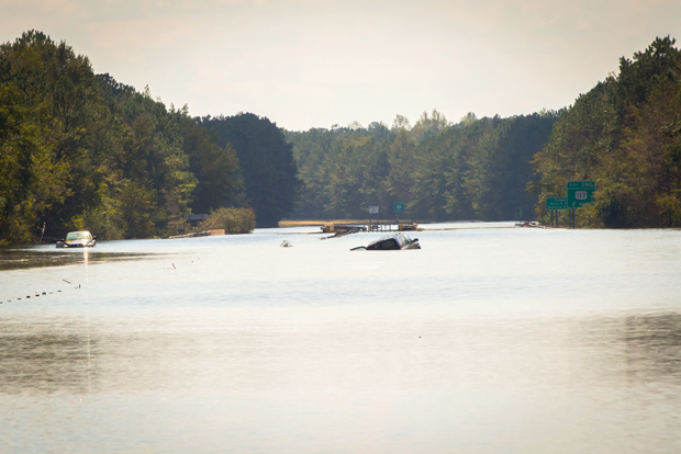 Photo of major flooding on I-40 in NC, with a stranded car