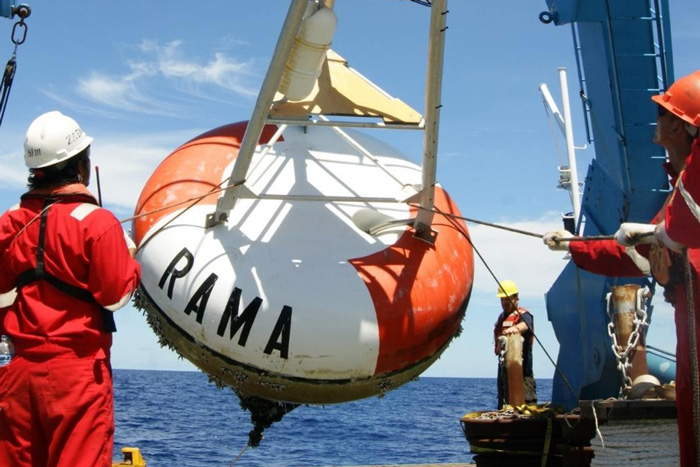 Photo of a RAMA buoy being pulled onto the deck of a ship