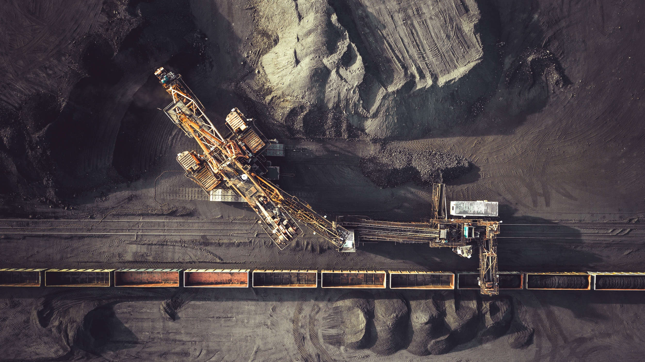 Aerial photo of coal yard with machines loading coal into train cars
