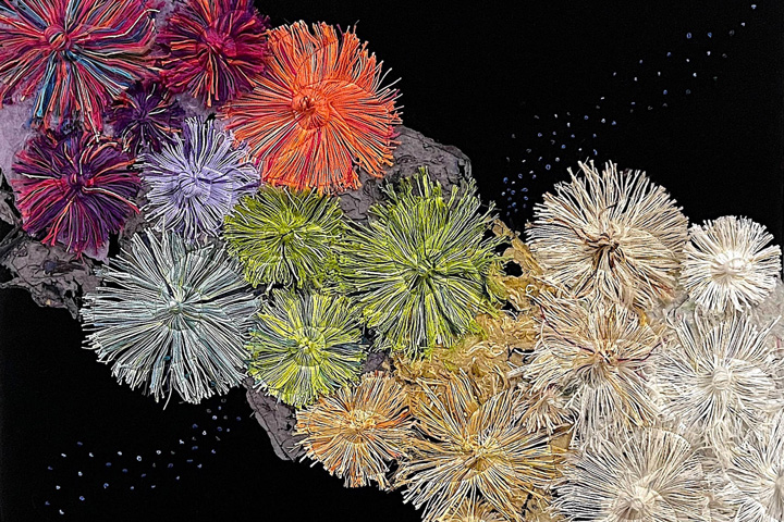 pinwheels of colored yarn stitched to paper