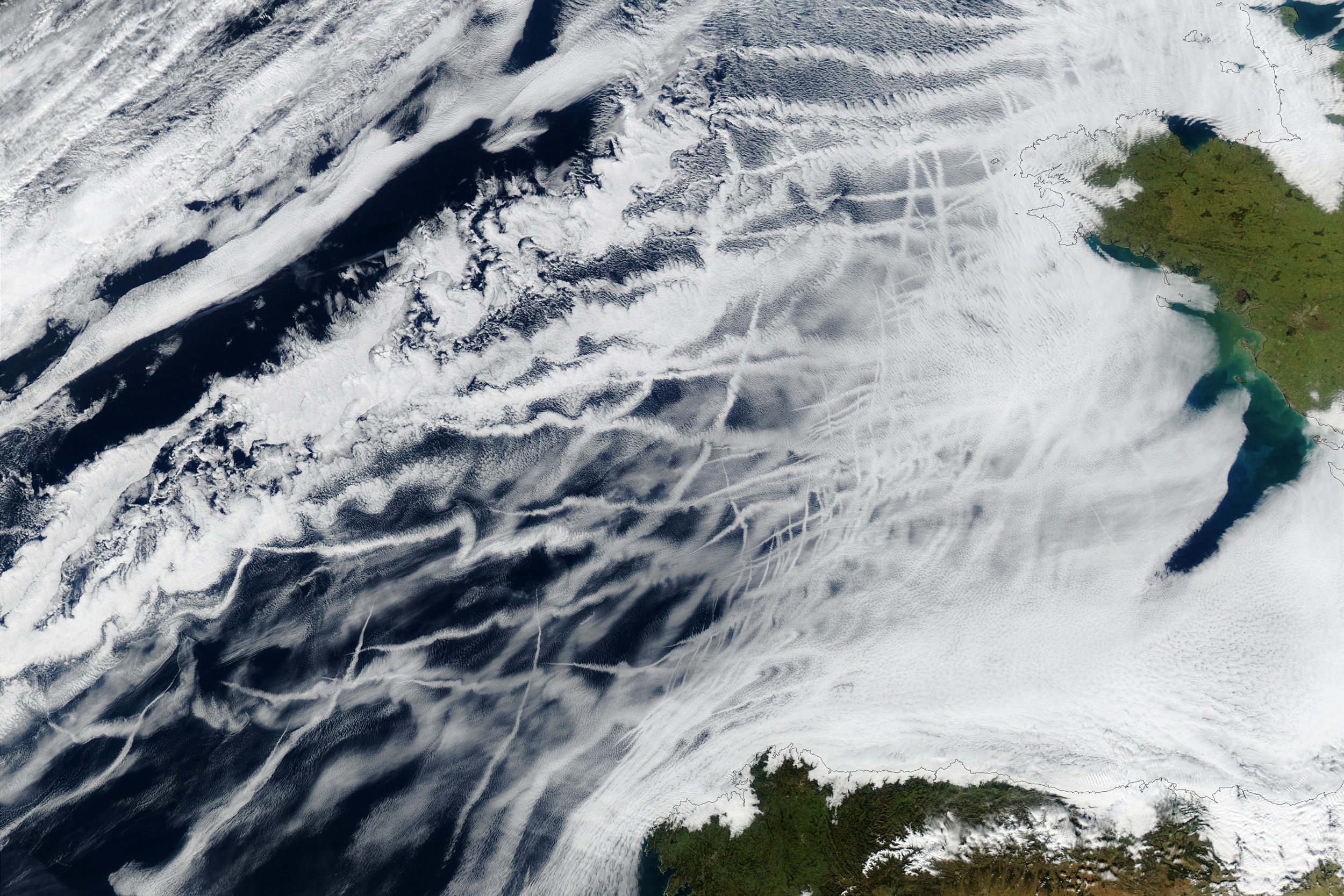 satellite image of white cloud streaks from ships above the Atlantic Ocean
