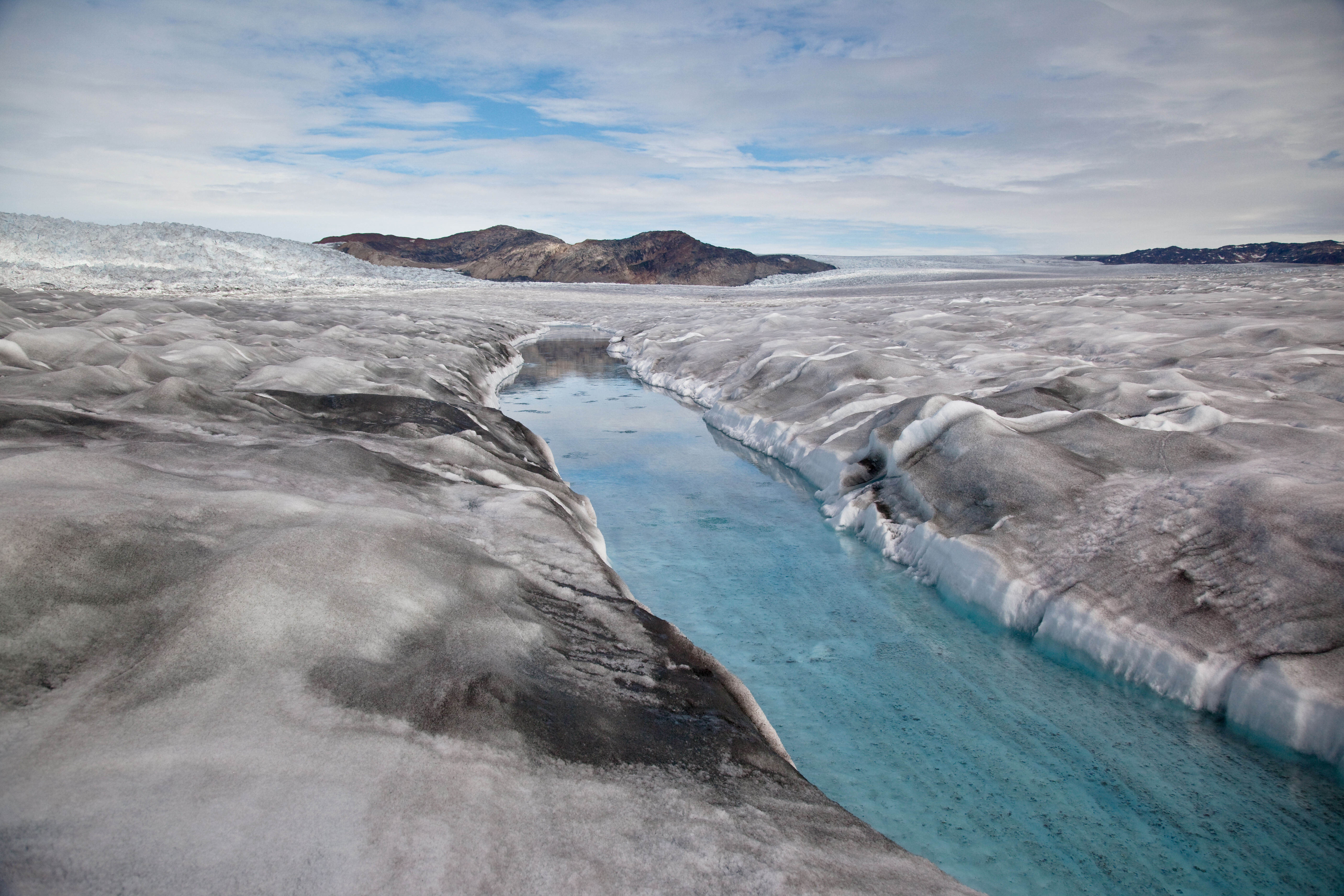 Photo of dirty ice surrounding a meltwater stream near the margin of the ice sheet.
