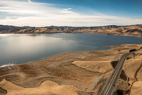 Aerial photo of San Luis Reservoir in CA surrounded by dry grassy areas