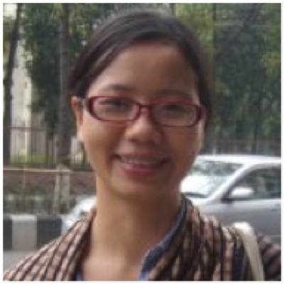 Professional headshot of Thuan Nguyen wearing red glasses and a printed sweater