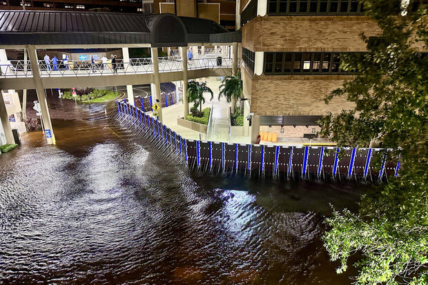A temporary sea wall protect the sidewalk and buildings of Tampa General Hospital from floodwaters on the outside