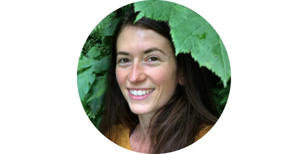 photo of a smiling woman framed by green leaves