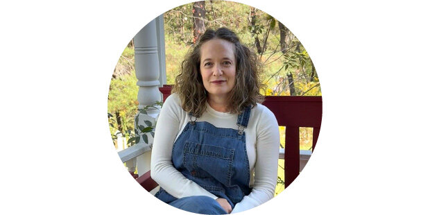 photo of a smiling woman wearing overalls, sitting on a bench