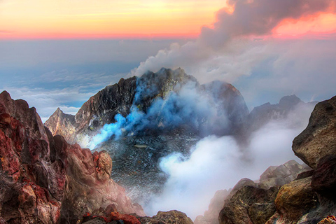 Photo of a volcanic caldera emitting steam and gas